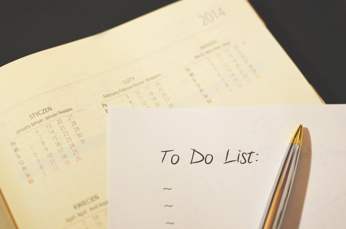 Caneta sobre uma lista de tarefas ao lado de um calendário