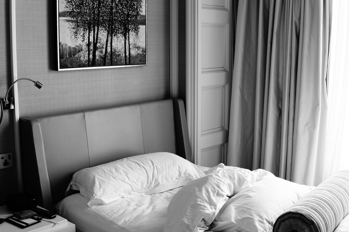 Cama arrumada em quarto tranquilo e organizado, ambiente ideal para dormir