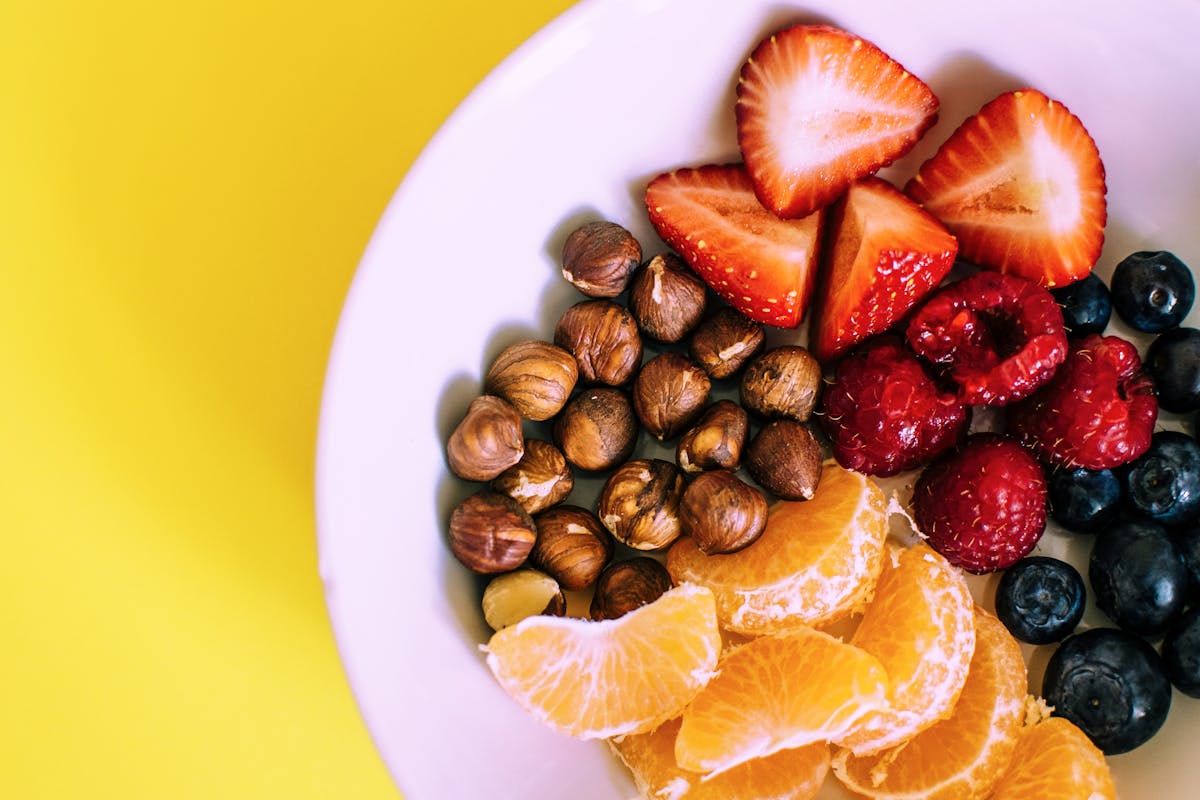 Tigela com frutas frescas e castanhas, opção de lanche saudável