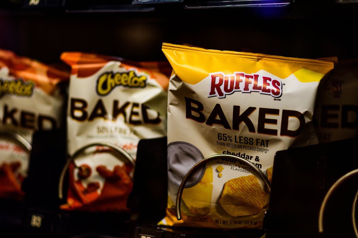 Máquina de venda repleta de salgadinhos e snacks ultraprocessados embalados