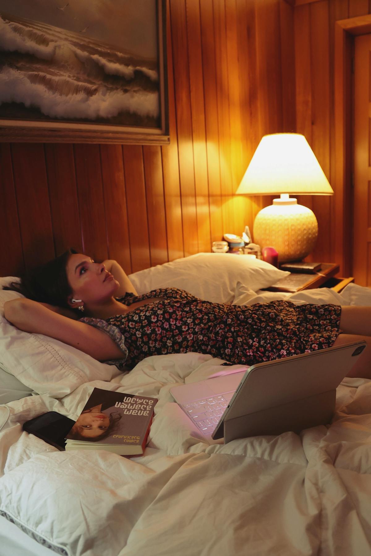 Mulher relaxando na cama com um livro em ambiente calmo à noite