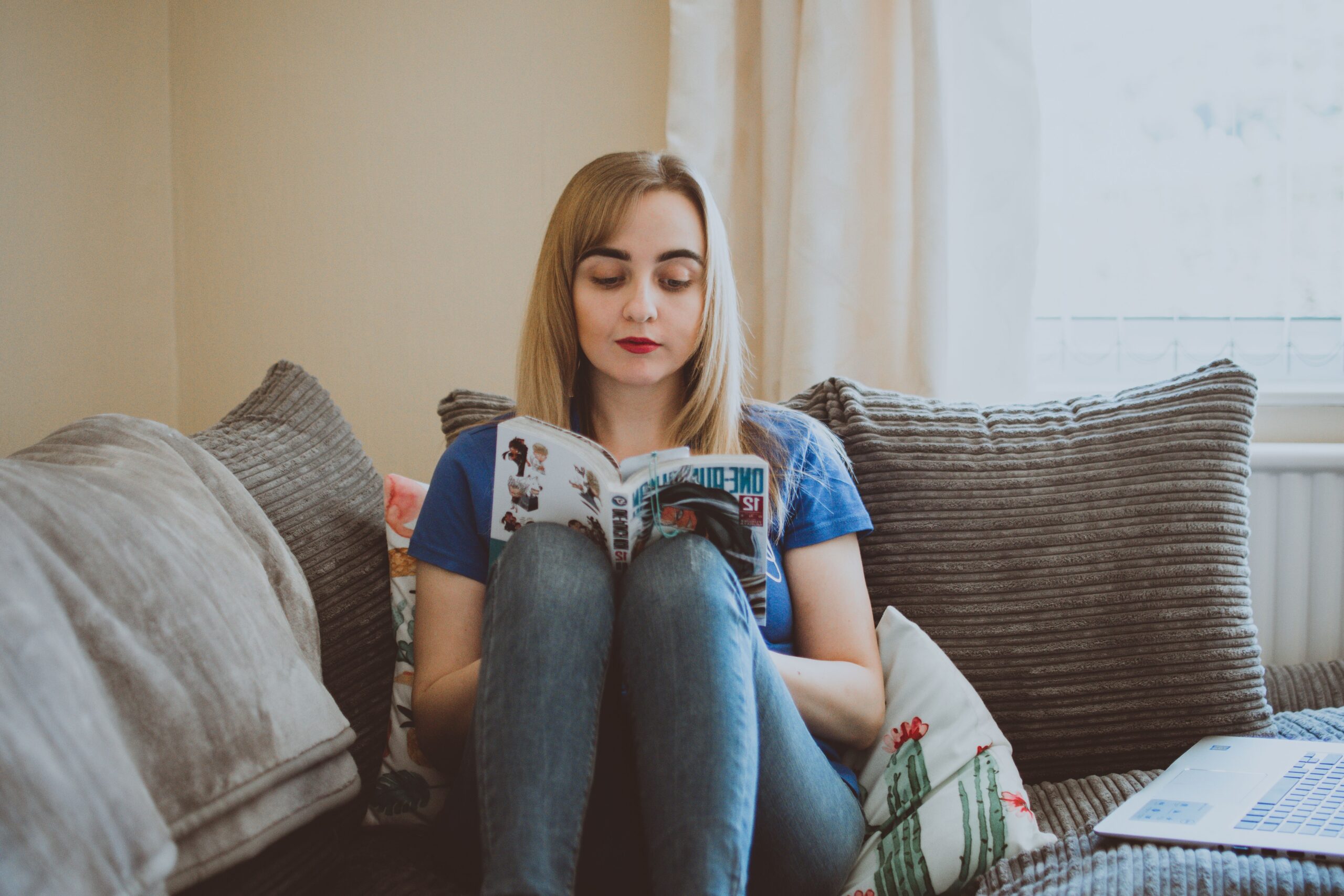 Mulher sentada no sofá lendo um livro, um momento offline