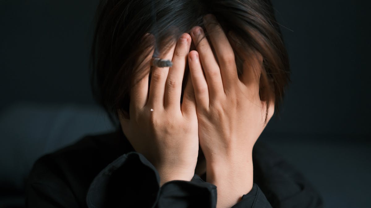 Mulher com as mãos no rosto demonstrando angústia e ansiedade