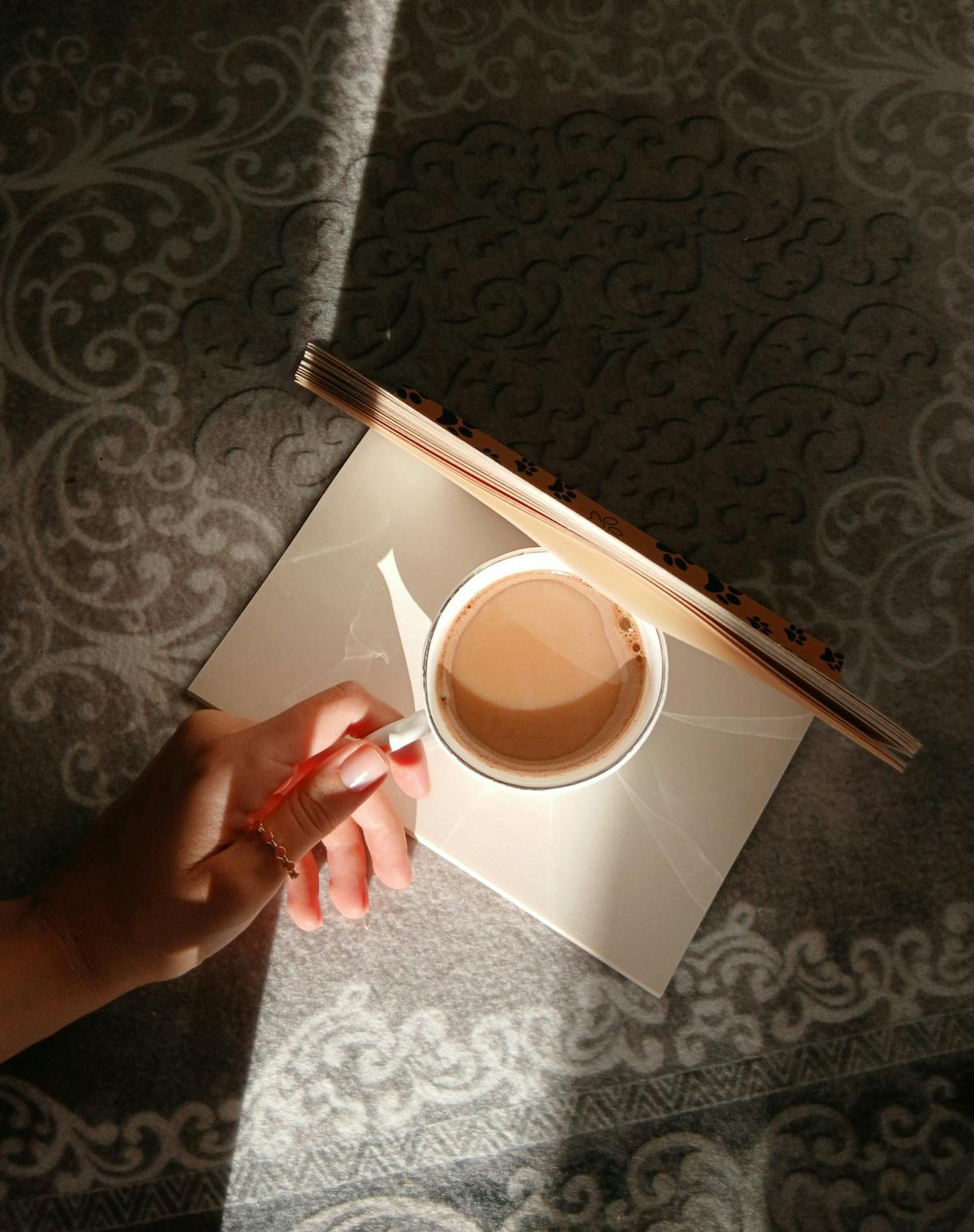 Xícara de café e diário sobre a mesa sob a luz da manhã
