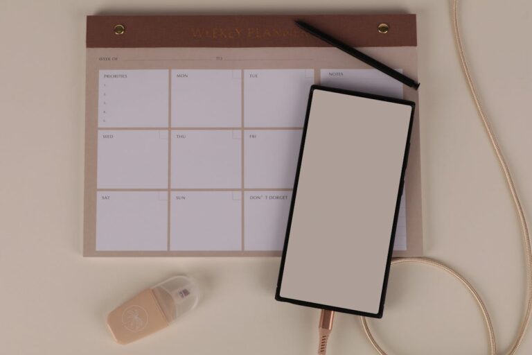 Mesa organizada com planner semanal, celular e materiais de planejamento