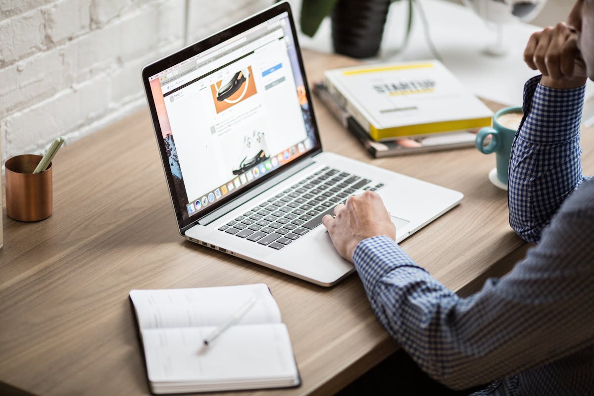Mesa com laptop, livros e xícara de café para estudo e trabalho