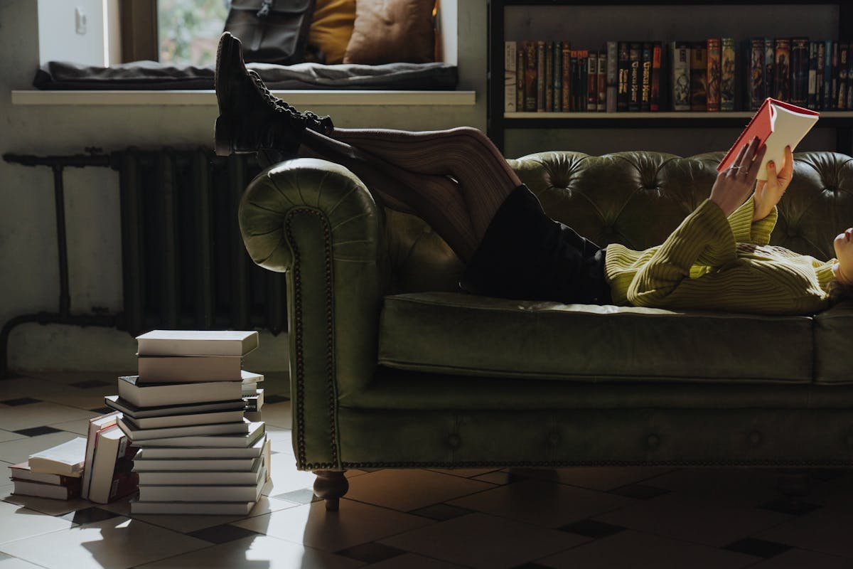 Pessoa deitada lendo um livro em momento de relaxamento antes de dormir