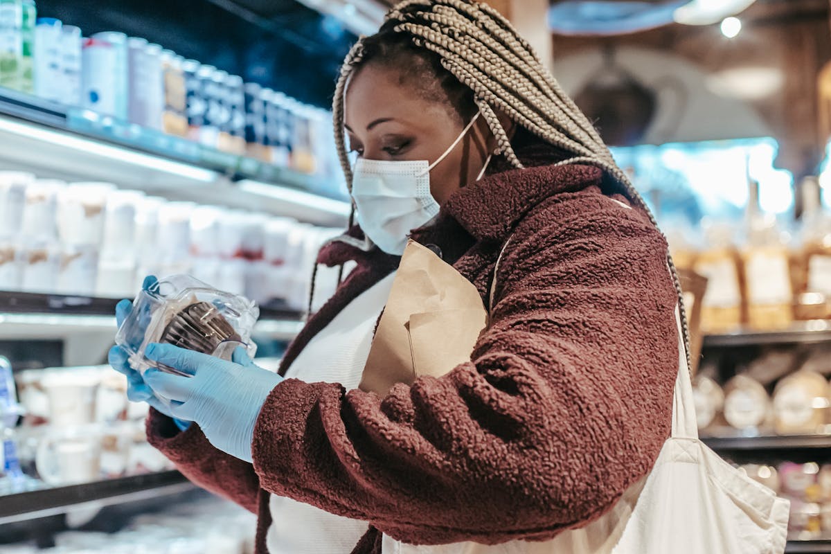 Mulher lendo o rótulo de um produto alimentício no supermercado