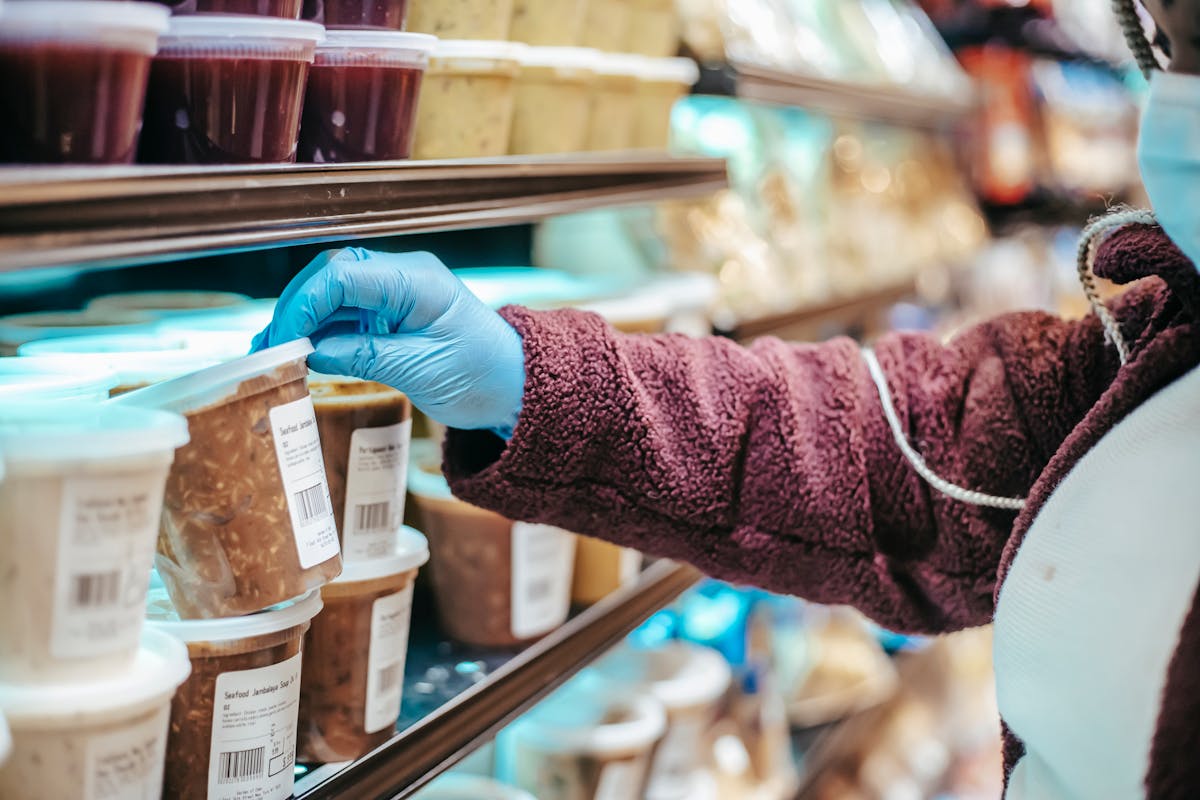 Mulher analisando um produto no supermercado antes de comprar