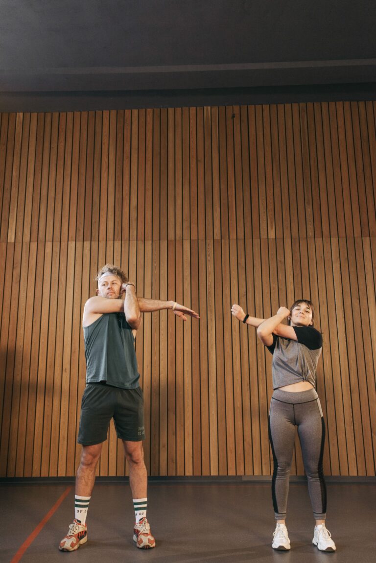 Homem e mulher fazendo alongamento antes do treino