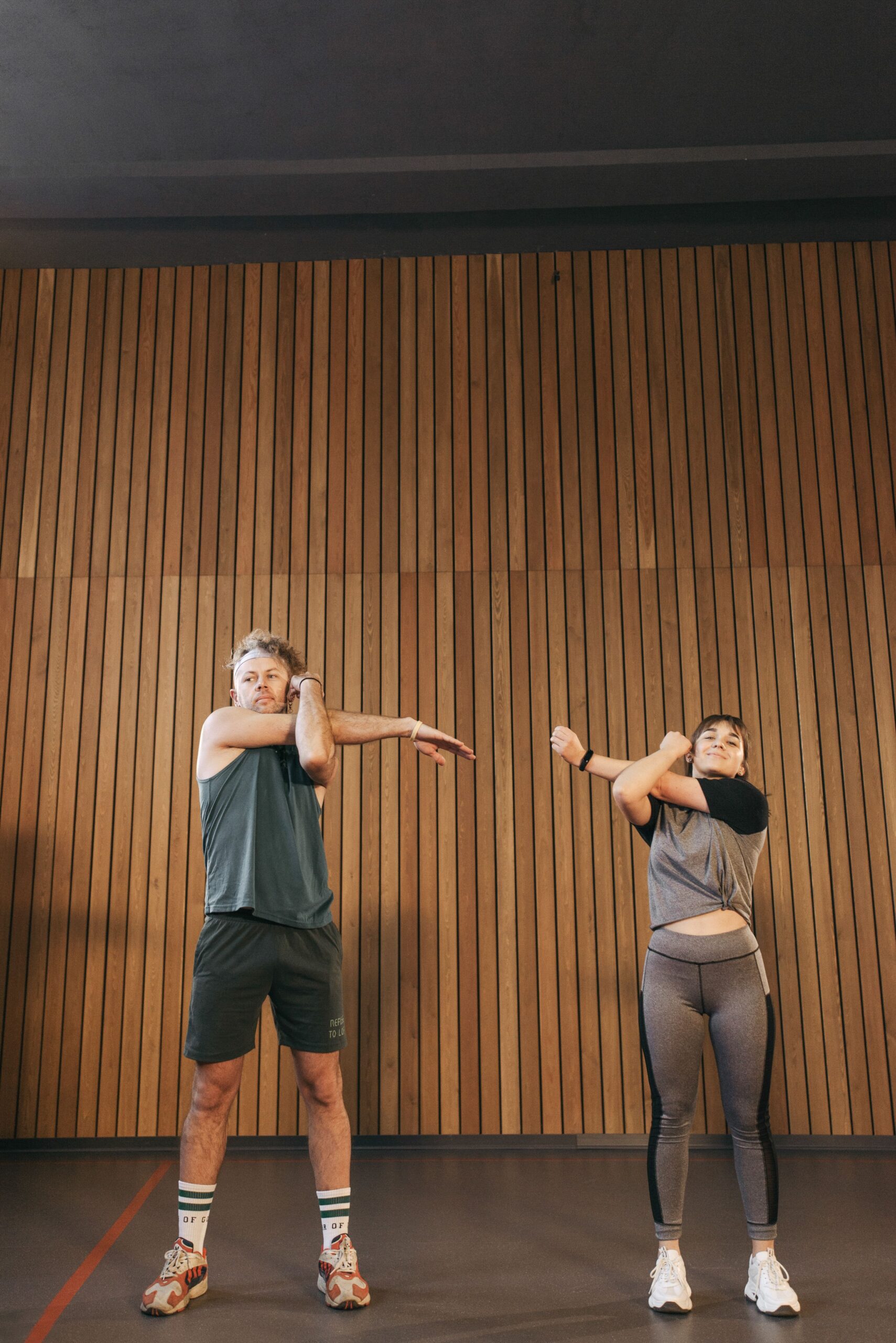 Homem e mulher fazendo alongamento antes do treino