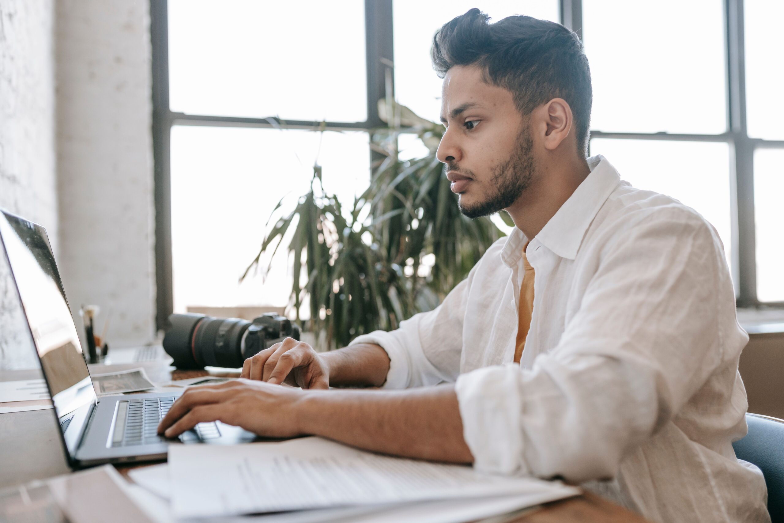 Homem focado trabalhando no laptop em uma mesa