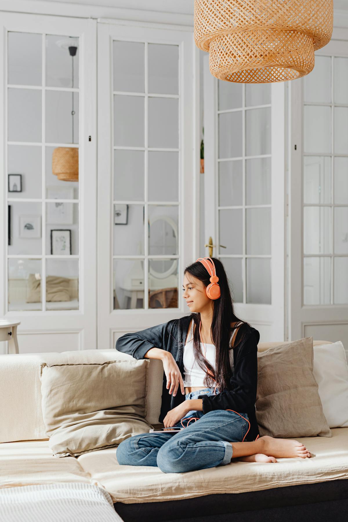 Mulher sentada no sofá usando fones de ouvido em momento de relaxamento