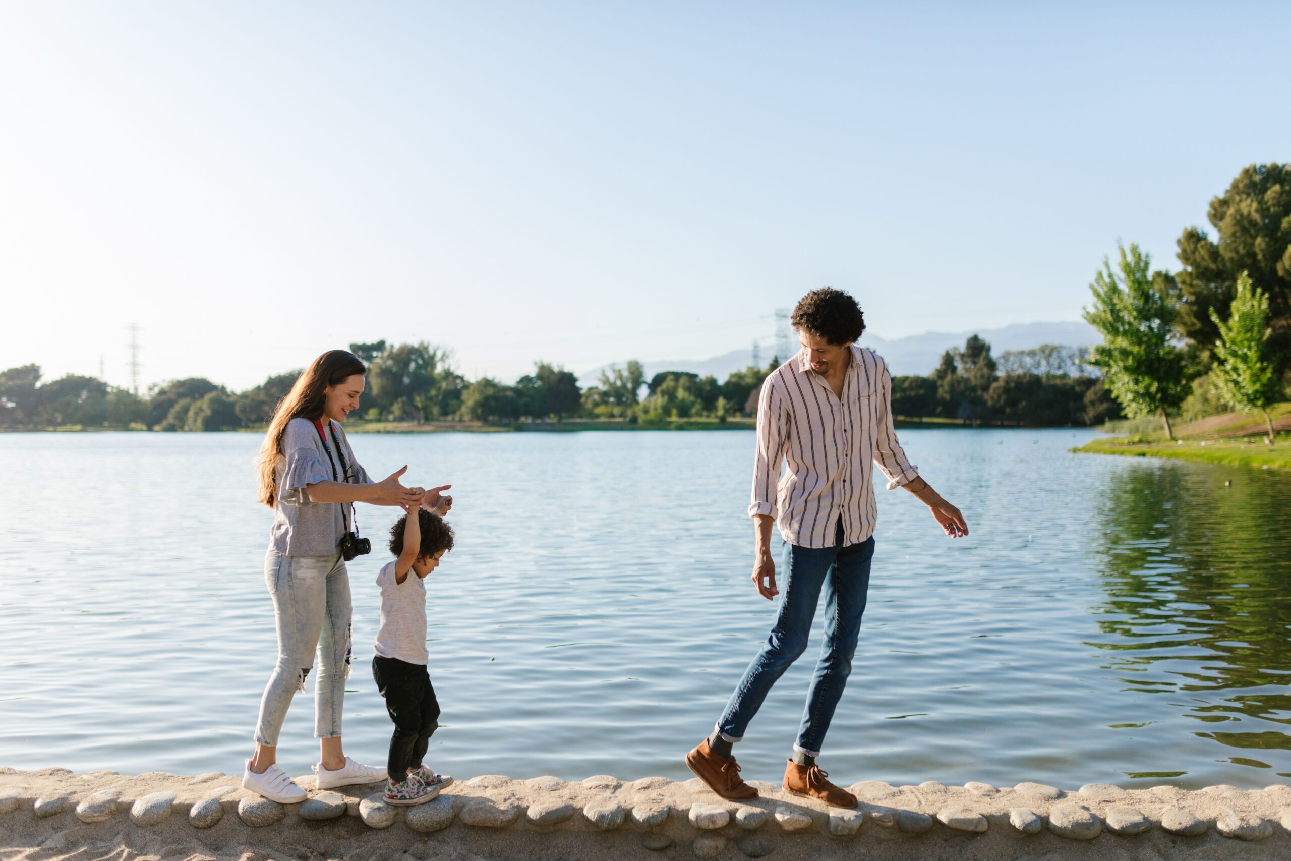 Família feliz caminhando e aproveitando o tempo livre juntos perto de um lago