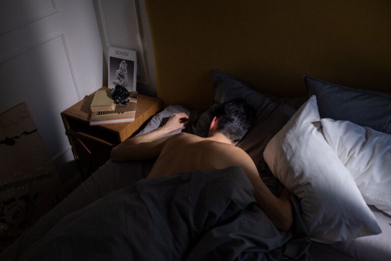 Pessoa dormindo tranquilamente na cama com luz suave em quarto aconchegante