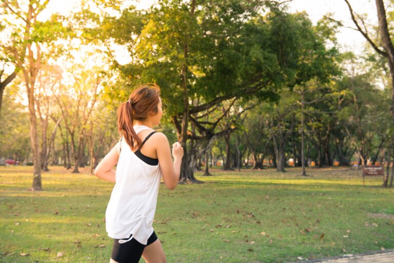 Mulher amarrando o tênis antes de correr ao ar livre no fim de tarde