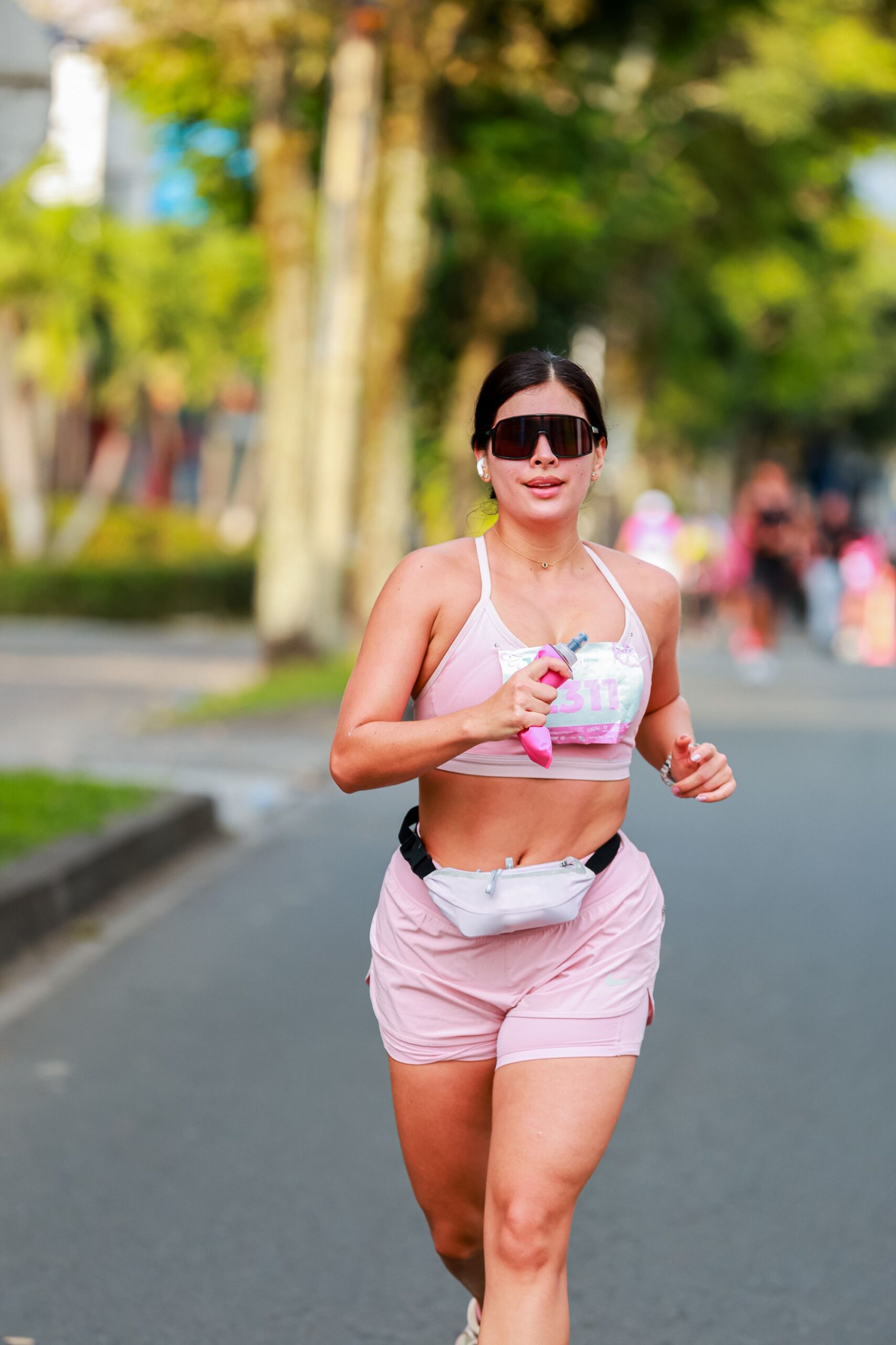 Mulher correndo ao ar livre em dia ensolarado com roupa esportiva colorida