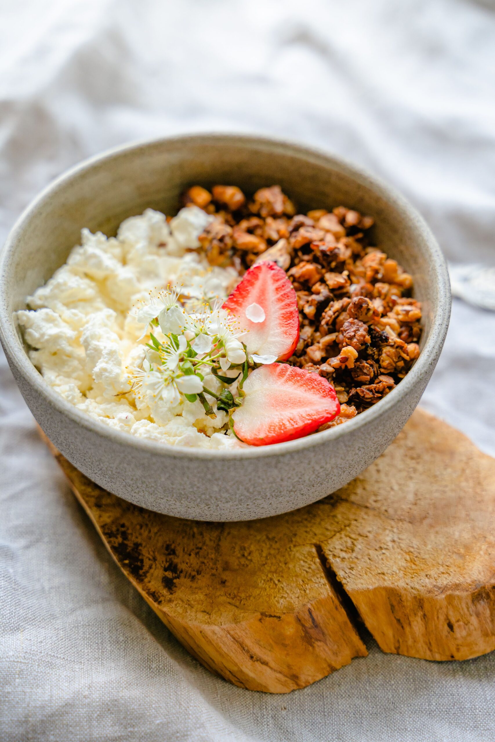 Tigela com queijo cottage, granola e morangos, lanche rico em proteína