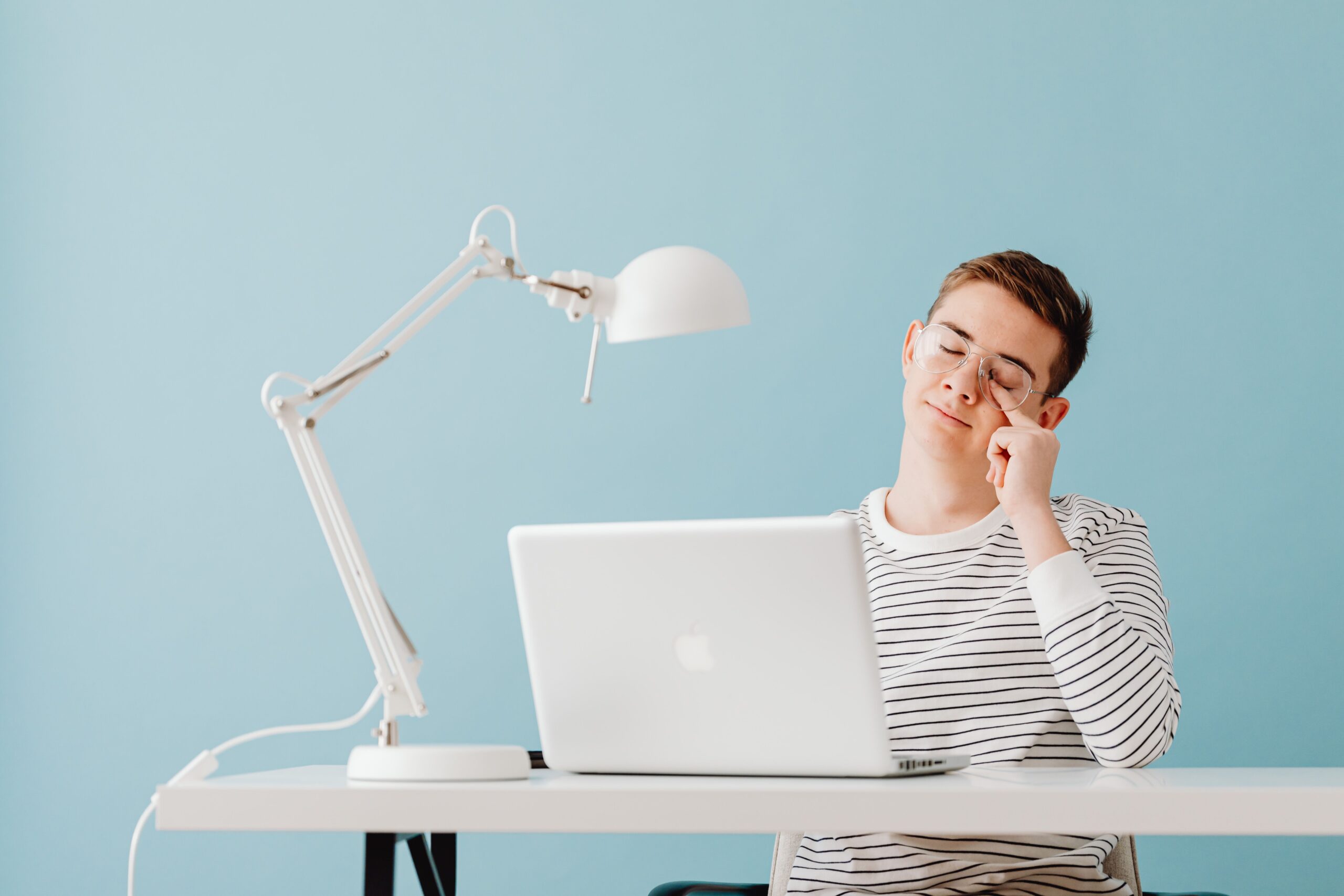 Homem com expressão de cansaço mental trabalhando no notebook