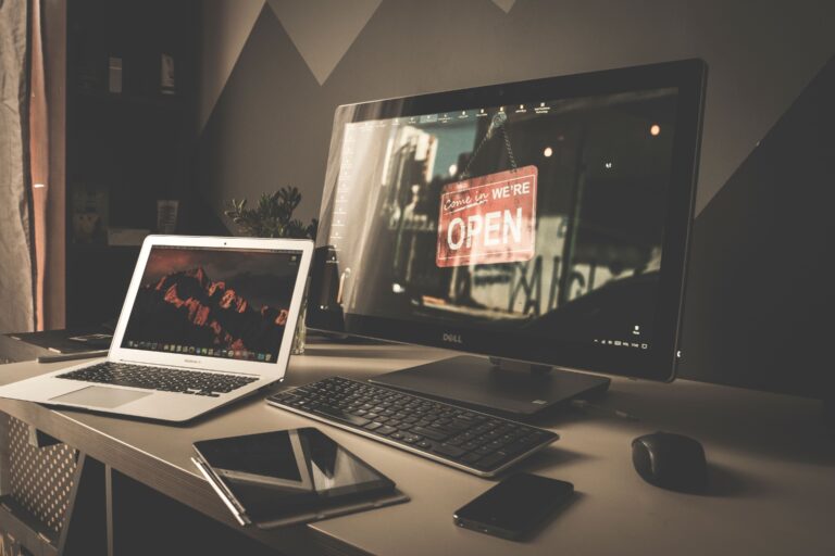 Computador e acessórios sobre uma mesa de trabalho organizada