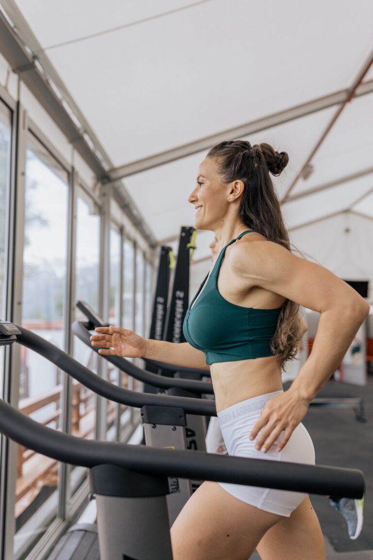 Mulher correndo em esteira dentro de uma academia