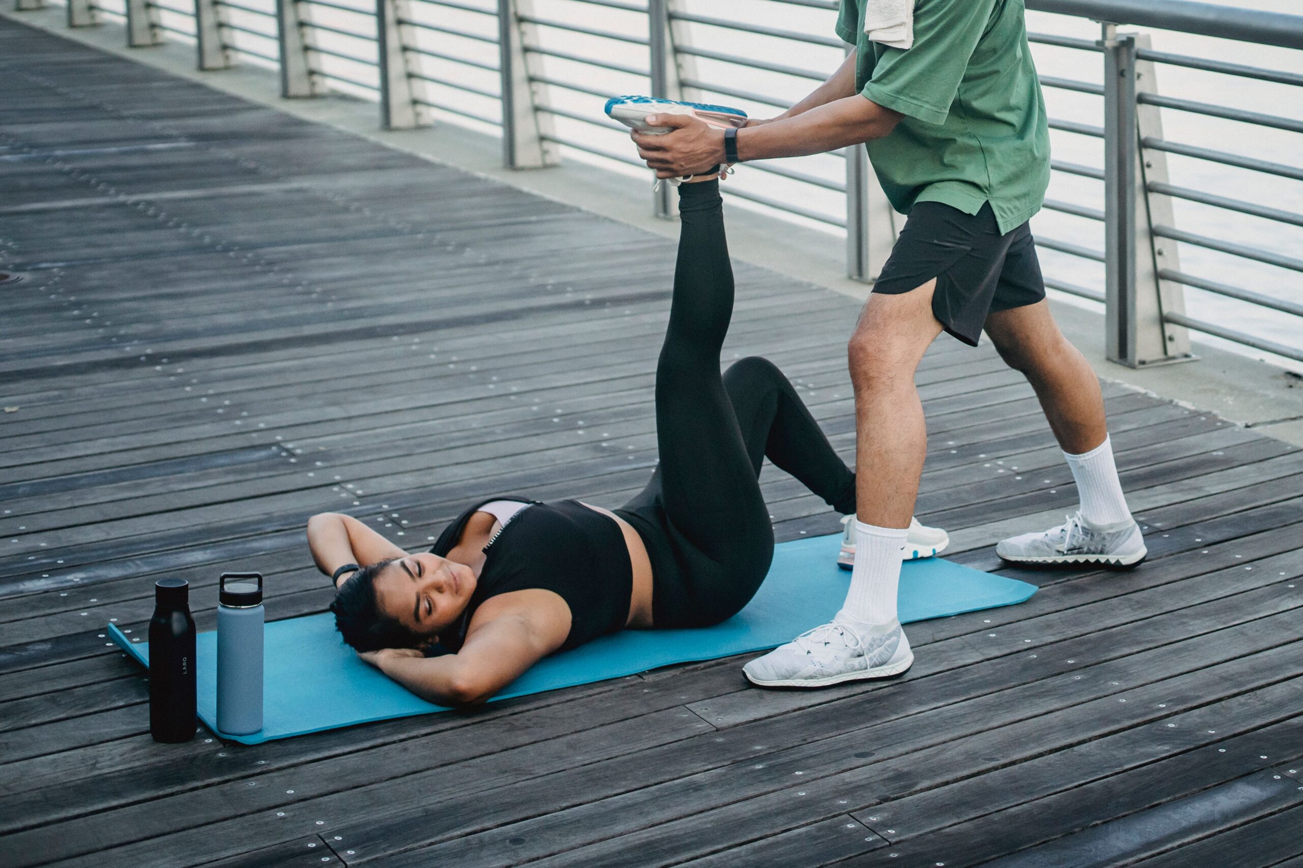 Pessoa deitada no tapete de yoga fazendo alongamento de recuperação
