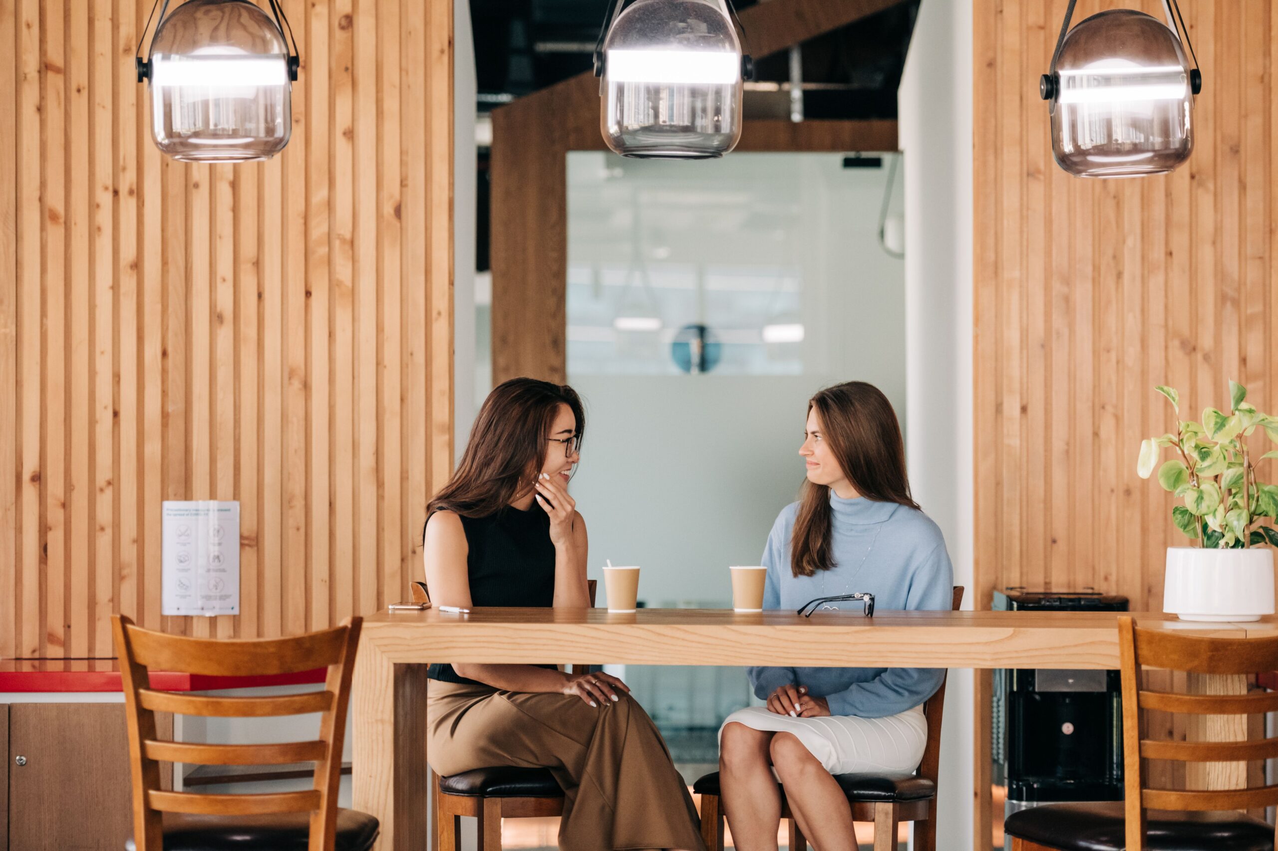 Amigos conversando animadamente em volta de uma mesa com café