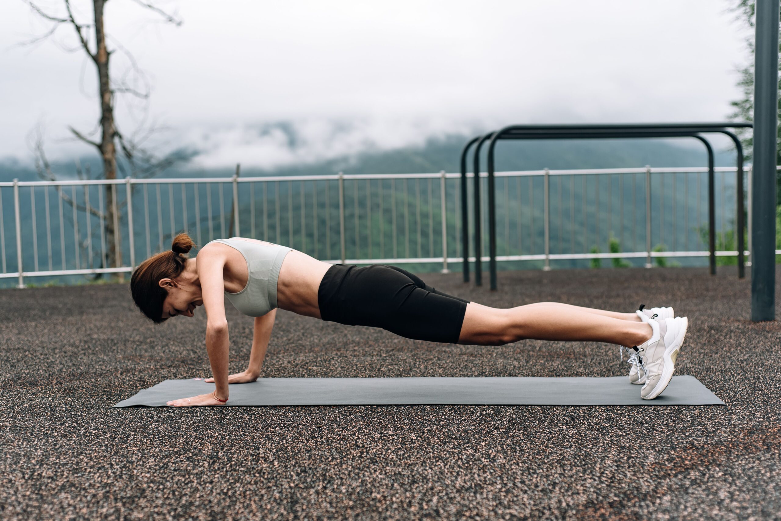 Pessoa em posição de prancha sobre tapete de exercícios