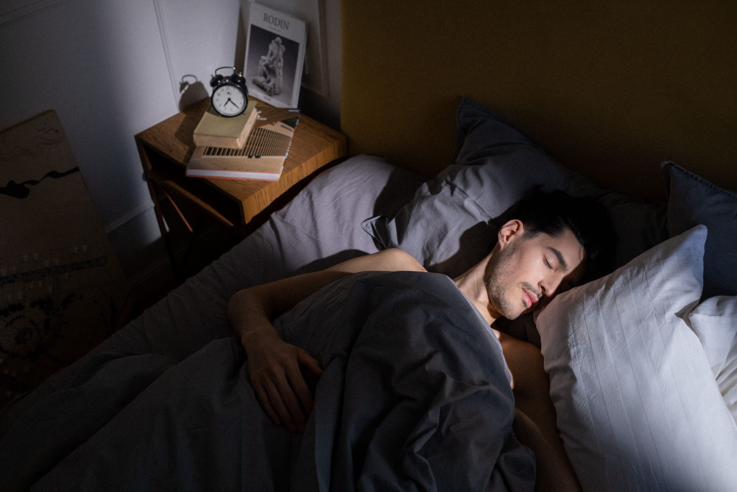 Homem na cama com a luz da manhã entrando pela janela